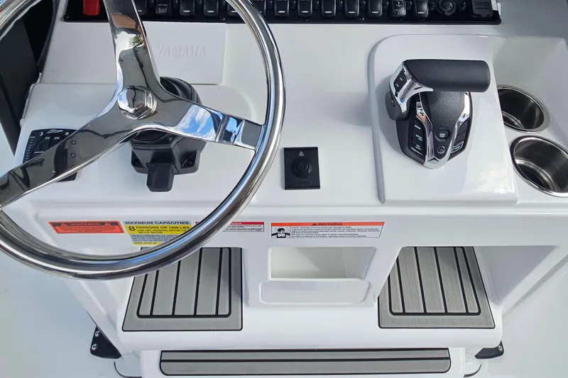 Slide: The Image of 2026 Sea Hunt Ultra 245 SE helm with steering wheel and controls. - 18