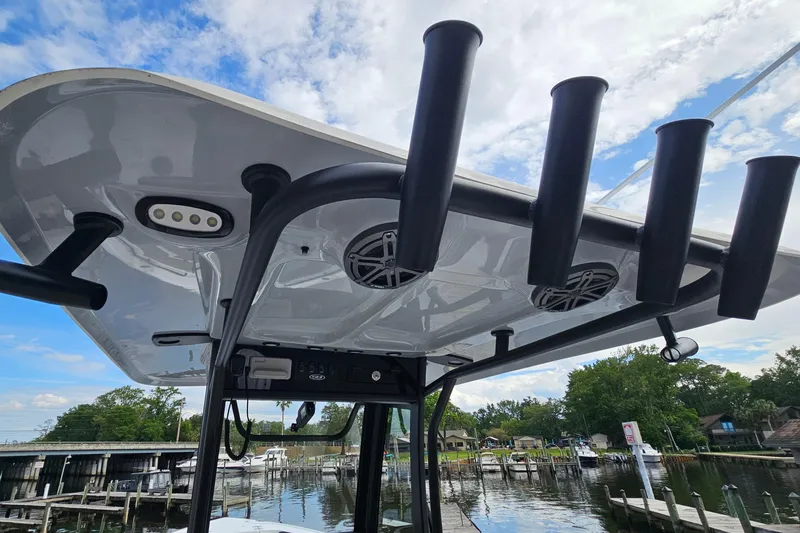 Slide: The Image of 2026 Sea Hunt Ultra 245 SE boat with rod holders and speakers at a marina. - 19