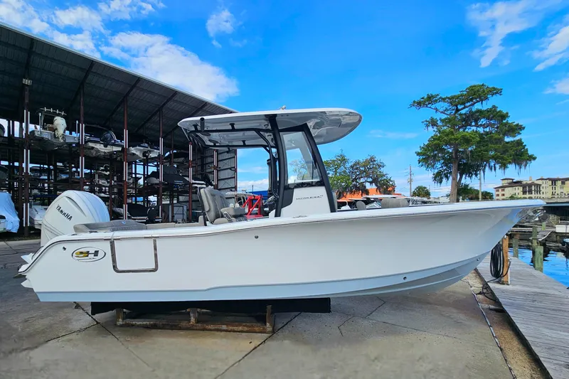 Slide: The Image of 2026 Sea Hunt Ultra 245 SE boat docked, featuring sleek design and Yamaha engine. - 2