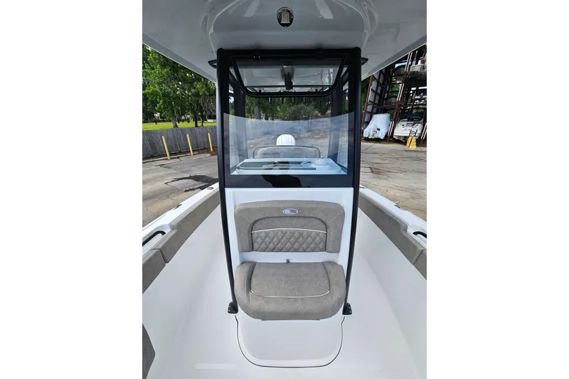 Slide: The Image of 2026 Sea Hunt Ultra 245 SE boat interior with cushioned seating and windshield. - 24