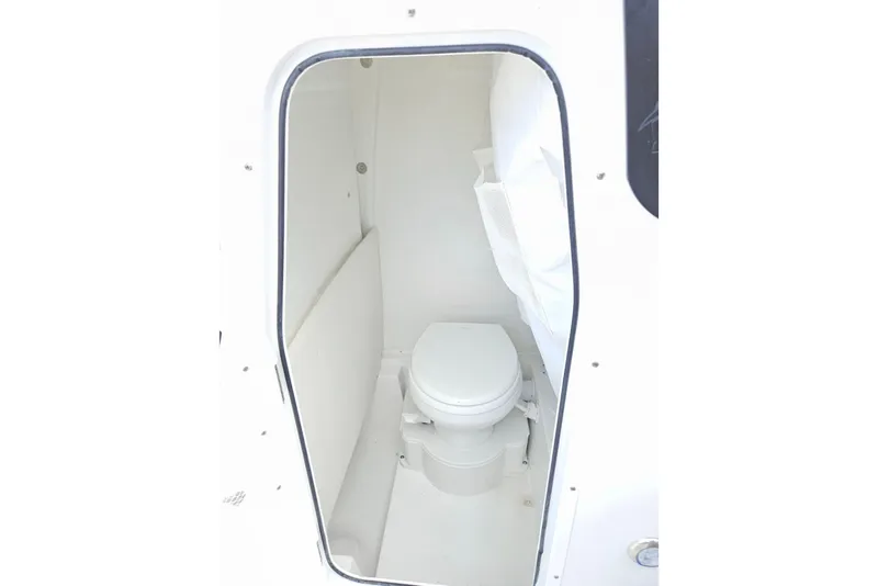 Slide: The Image of Interior view of 2026 Sea Hunt Ultra 245 SE boat's compact marine toilet. - 27