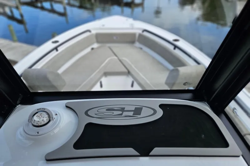 Slide: The Image of 2026 Sea Hunt Ultra 245 SE boat interior with compass and seating area. - 31
