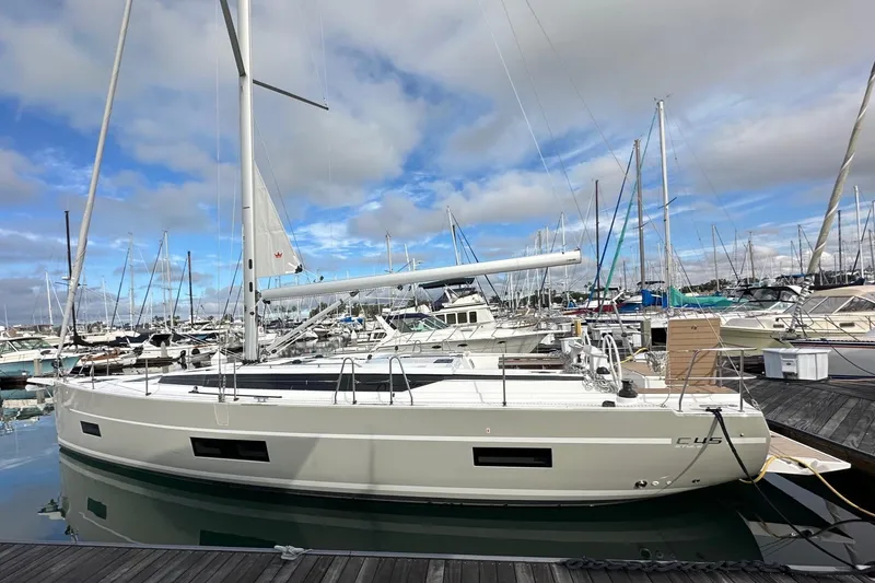 Slide: The Image of 2024 Bavaria C45 sailboat docked in a marina under a cloudy sky. - 1