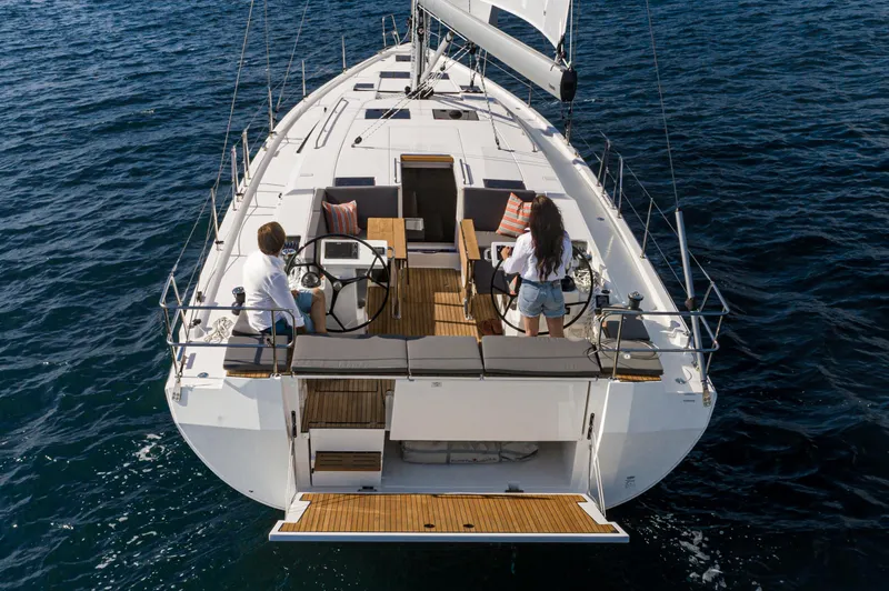Slide: The Image of 2024 Bavaria C45 sailboat on open water, featuring spacious deck and dual steering wheels. - 13