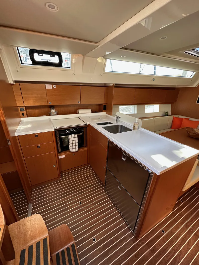 Slide: The Image of 2024 Bavaria C45 yacht interior with modern kitchen and sleek wooden finishes. - 36