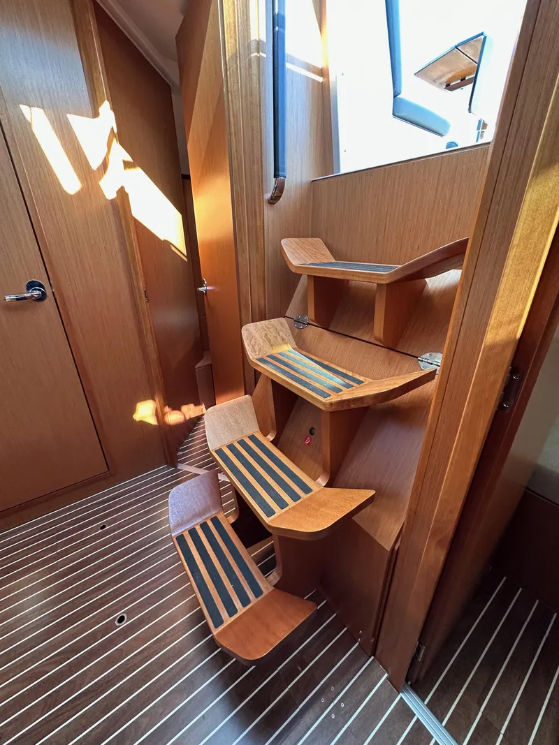 Slide: The Image of Interior of 2024 Bavaria C45 yacht with wooden stairs and striped flooring. - 43