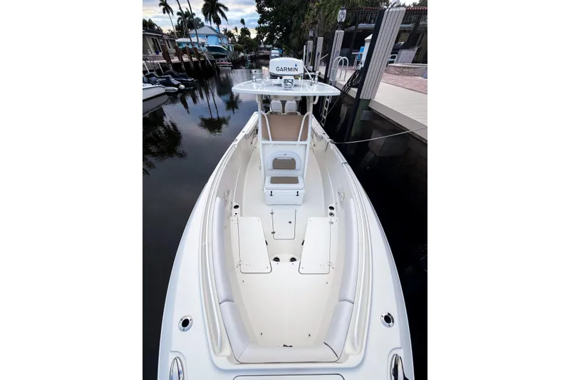 Slide: The Image of 2016 Sailfish 290 CC boat docked in a serene canal setting. - 1