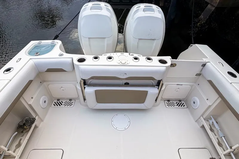 Slide: The Image of 2016 Sailfish 290 CC boat deck with dual engines and fishing rod holders. - 10