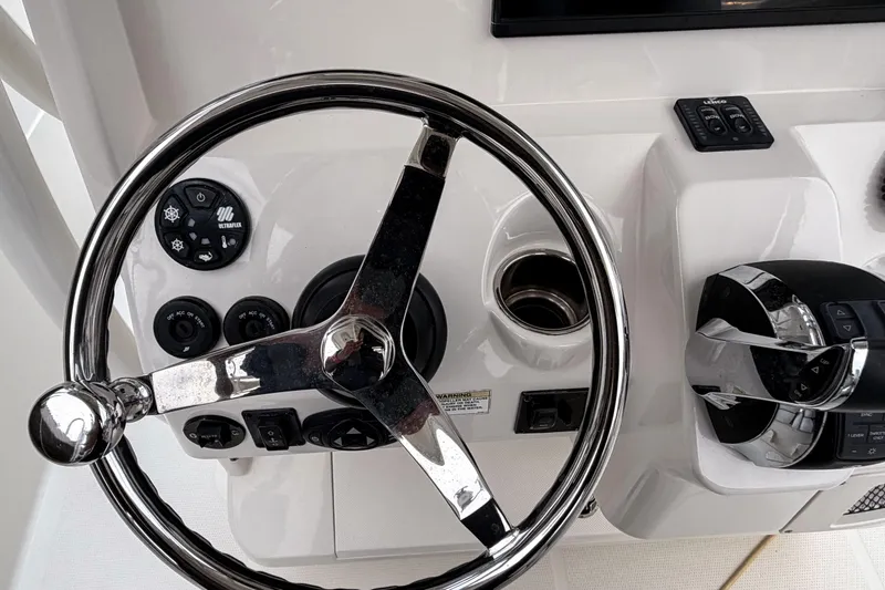 Slide: The Image of Steering wheel and controls of a 2016 Sailfish 290 CC boat cockpit. - 19