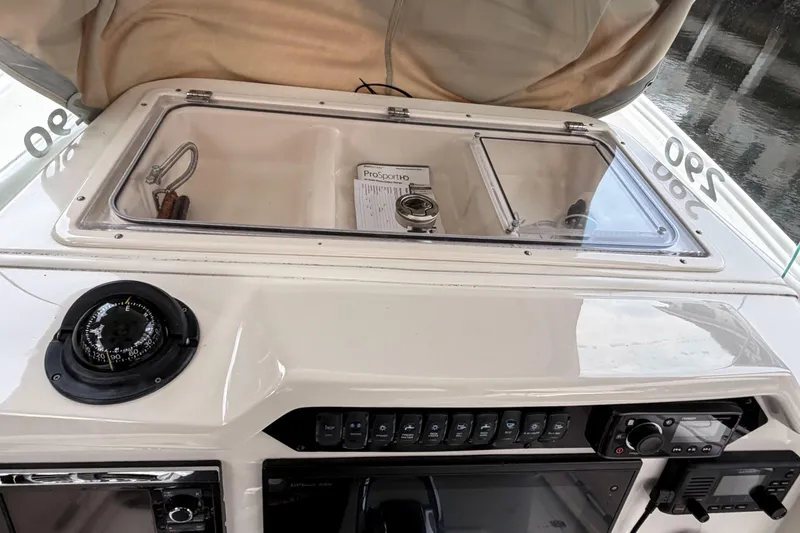 Slide: The Image of Control panel of a 2016 Sailfish 290 CC boat with compass and storage compartment. - 21