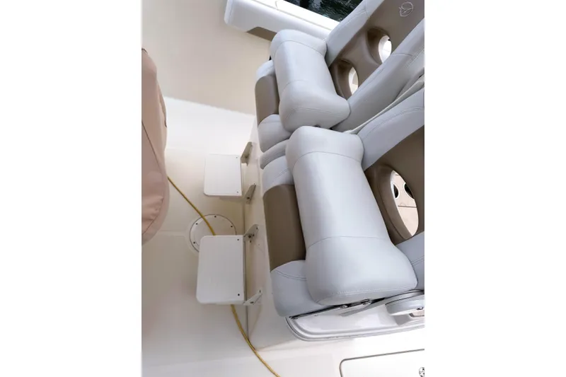Slide: The Image of 2016 Sailfish 290 CC boat seating with white cushioned seats and footrests. - 24
