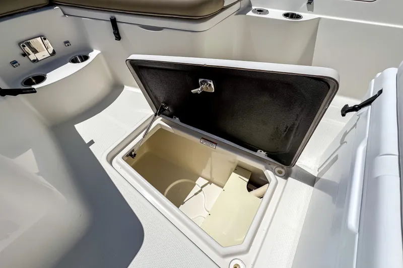 Slide: The Image of 2016 Sailfish 290 CC boat interior with storage compartments and beige cover. - 28
