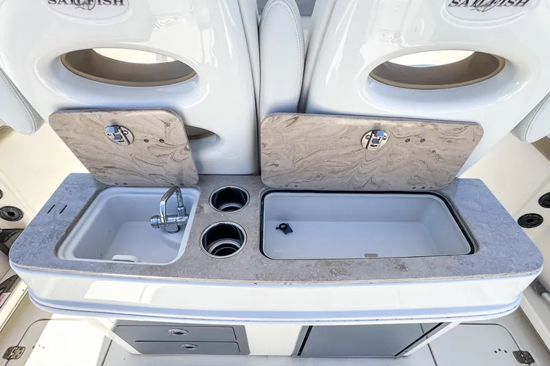 Slide: The Image of 2016 Sailfish 290 CC boat sink and storage area with cup holders. - 32