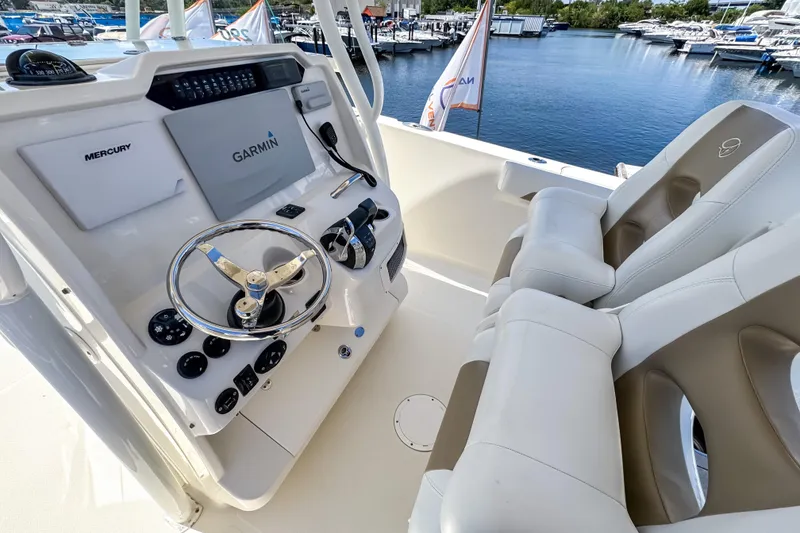 Slide: The Image of 2016 Sailfish 290 CC boat cockpit with Garmin and Mercury controls, dual seating, docked at marina. - 34