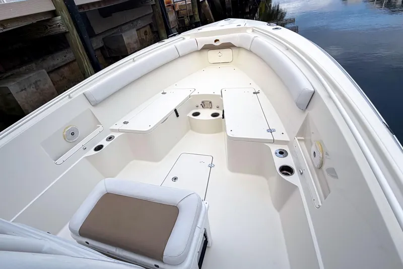 Slide: The Image of 2016 Sailfish 290 CC boat interior with cushioned seating and storage compartments. - 4