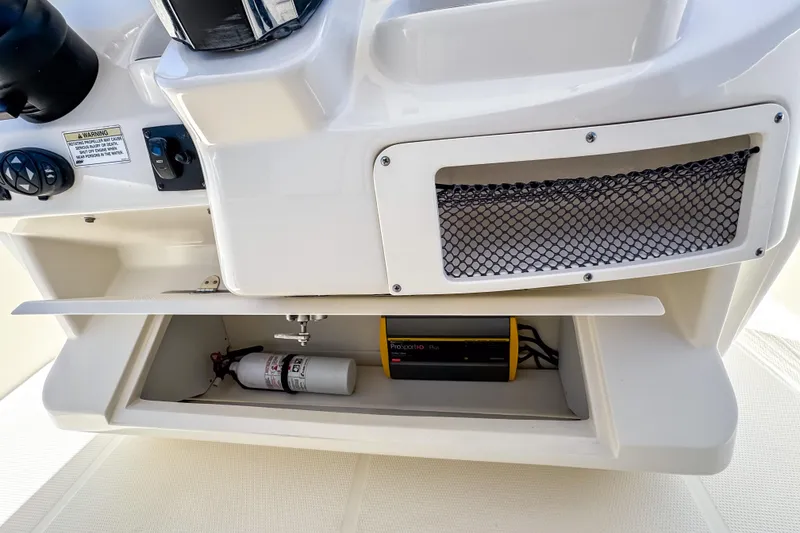 Slide: The Image of Storage compartment on a 2016 Sailfish 290 CC boat with fire extinguisher and equipment. - 42