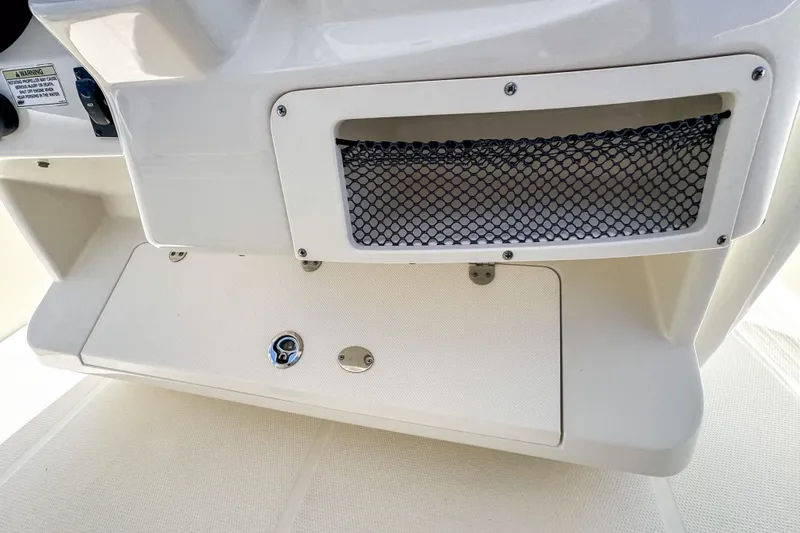 Slide: The Image of 2016 Sailfish 290 CC boat interior detail with storage compartment and netting. - 43