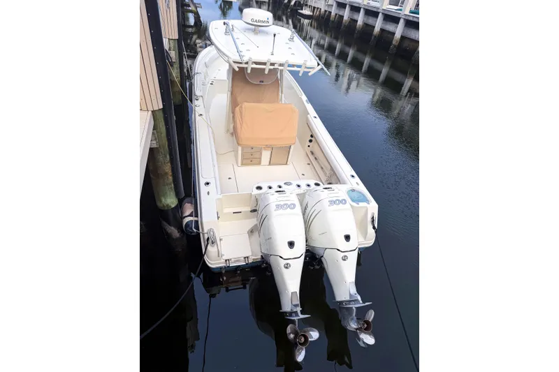 Slide: The Image of 2016 Sailfish 290 CC boat with twin 300 horsepower engines docked in calm waters. - 9