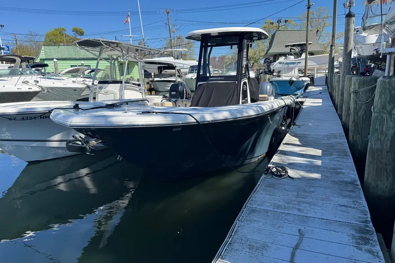 The Image of 2022 Tidewater 256 CC Adventure boat docked at a marina under clear blue skies. - 1