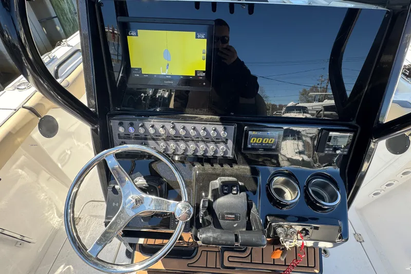 Slide: The Image of 2022 Tidewater 256 CC Adventure boat dashboard with steering wheel and navigation display. - 12