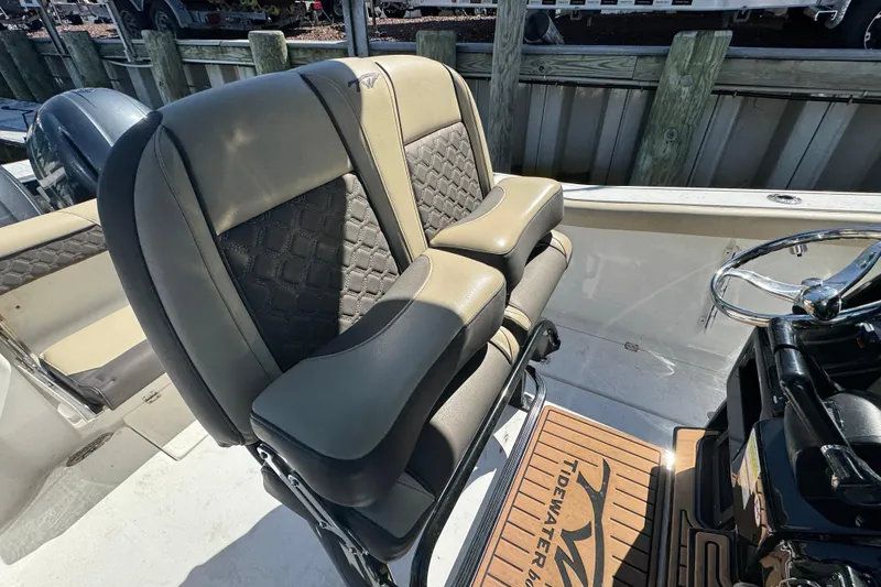 Slide: The Image of 2022 Tidewater 256 CC Adventure boat seats with premium upholstery and steering wheel. - 13