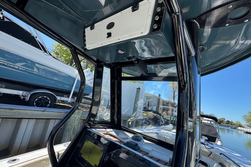Slide: The Image of 2022 Tidewater 256 CC Adventure boat interior with sleek black frame and modern dashboard. - 15