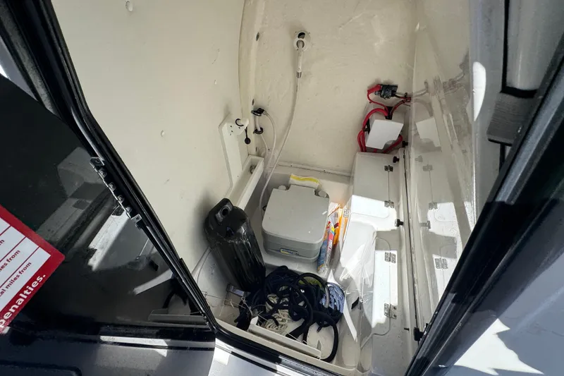 Slide: The Image of Interior storage compartment of 2022 Tidewater 256 CC Adventure boat, featuring various equipment. - 17