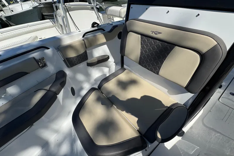 Slide: The Image of 2022 Tidewater 256 CC Adventure boat interior with beige and black seating. - 19