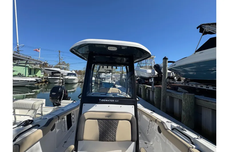 Slide: The Image of 2022 Tidewater 256 CC Adventure boat docked in a marina under clear blue skies. - 25