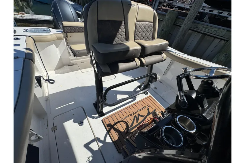Slide: The Image of 2022 Tidewater 256 CC Adventure boat interior with dual seats and steering console. - 27