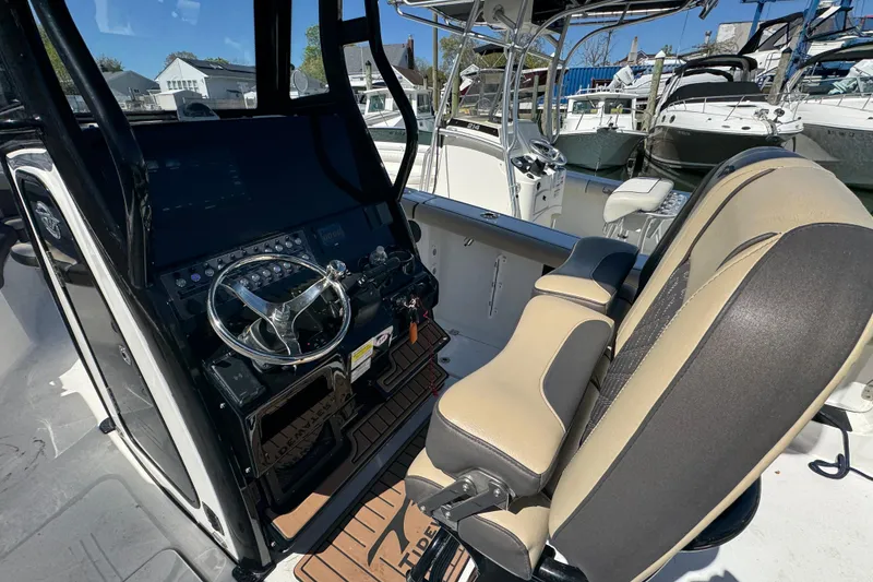 Slide: The Image of 2022 Tidewater 256 CC Adventure boat cockpit with steering wheel and seating. - 6