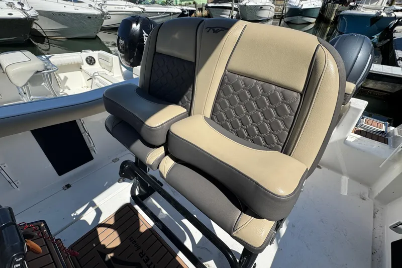 Slide: The Image of 2022 Tidewater 256 CC Adventure boat seats with stylish upholstery in a marina setting. - 8