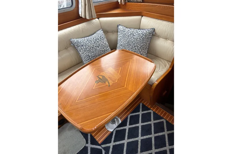 Slide: The Image of Luxurious Nauticat Staysail Ketch 2001 interior with elegant wood table and patterned cushions. - 12