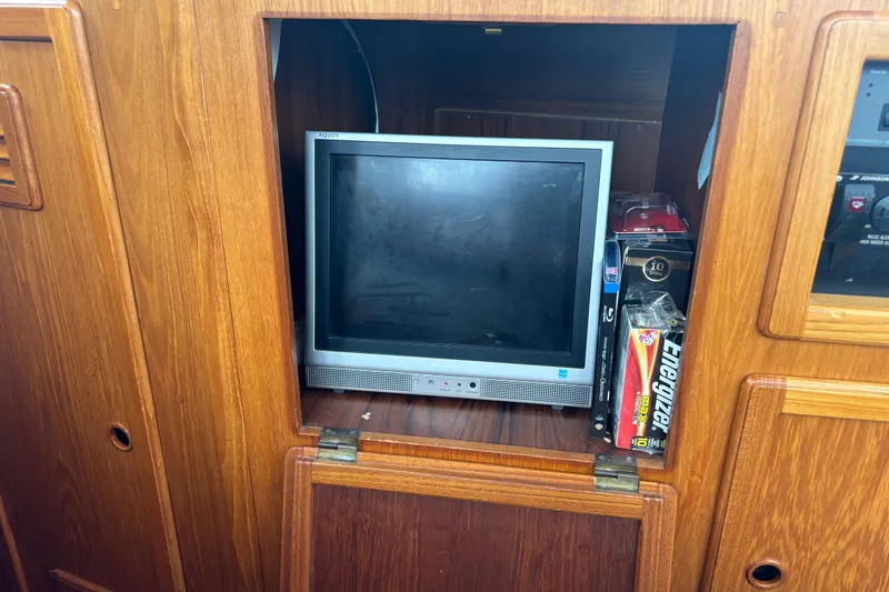 Slide: The Image of Small TV and batteries in wooden cabinet on 2001 Nauticat Staysail Ketch yacht. - 14