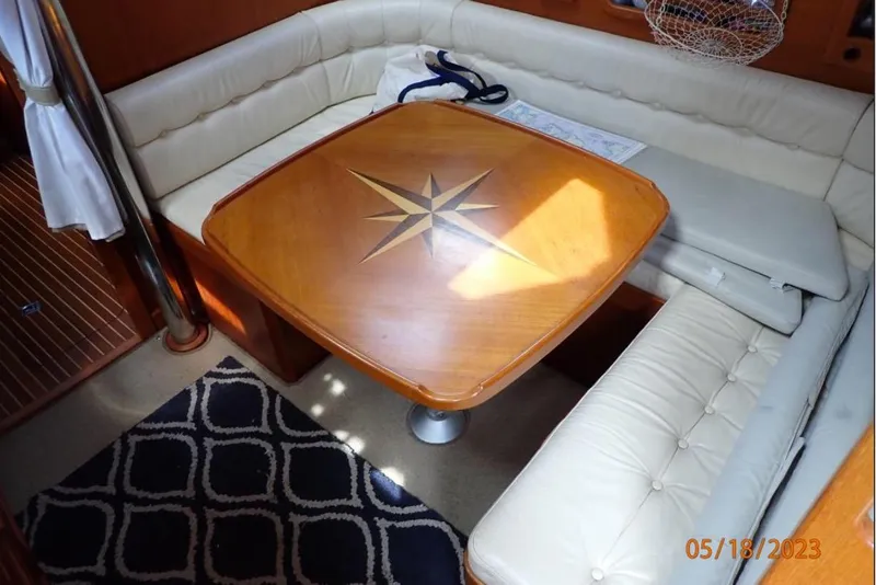 Slide: The Image of Interior of 2001 Nauticat Staysail Ketch with cushioned seating and wooden table. - 20