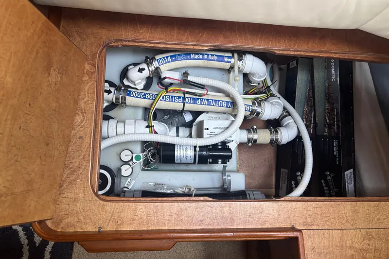 Slide: The Image of Engine compartment of a 2001 Nauticat Staysail Ketch, showcasing plumbing and wiring systems. - 22