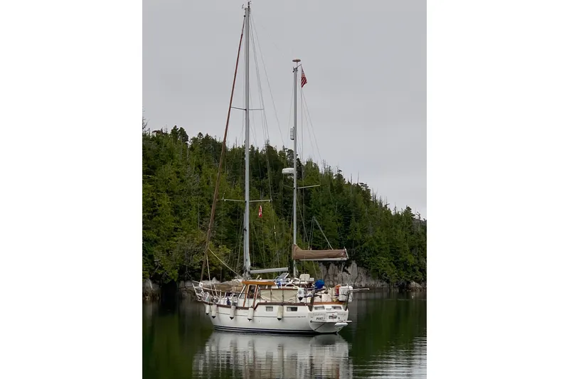 Slide: The Image of Sailing yacht Nauticat Staysail Ketch 2001 anchored in a serene forested bay. - 3