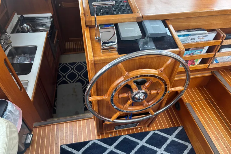 Slide: The Image of Interior of 2001 Nauticat Staysail Ketch with wooden helm and compact kitchen area. - 6