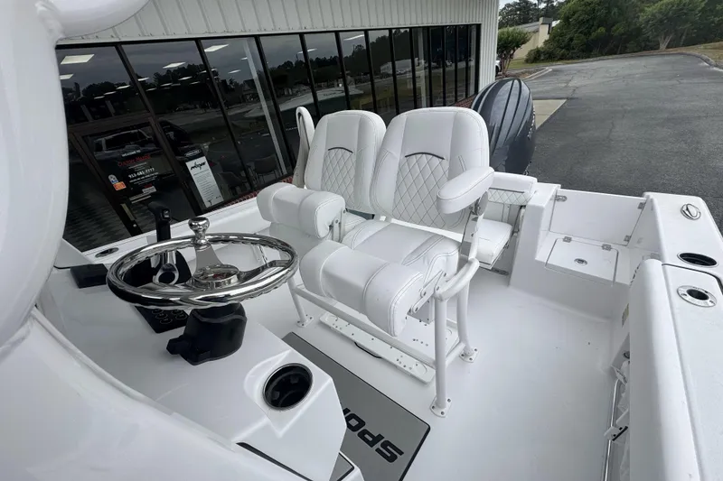 Slide: The Image of 2026 Sportsman Open 212 Center Console boat with white seating and steering wheel. - 18