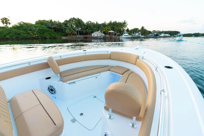 Slide: The Image of Manufacturer Provided Image: 2025 Sportsman Open 212 Center Console boat with tan seating, cruising near lush shoreline. - 24