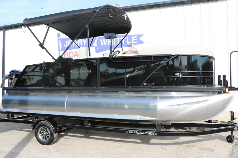 The Image of 2026 Sylvan Mirage 820 CLZ DH Premium Pontoon on trailer, sleek design, black canopy. - 0