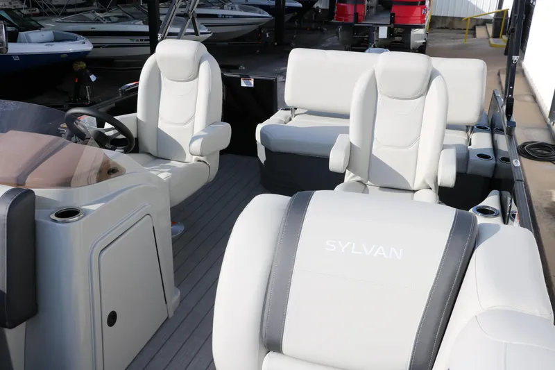 Slide: The Image of 2026 Sylvan Mirage 820 CLZ DH Premium Pontoon interior with plush seating and steering console. - 13