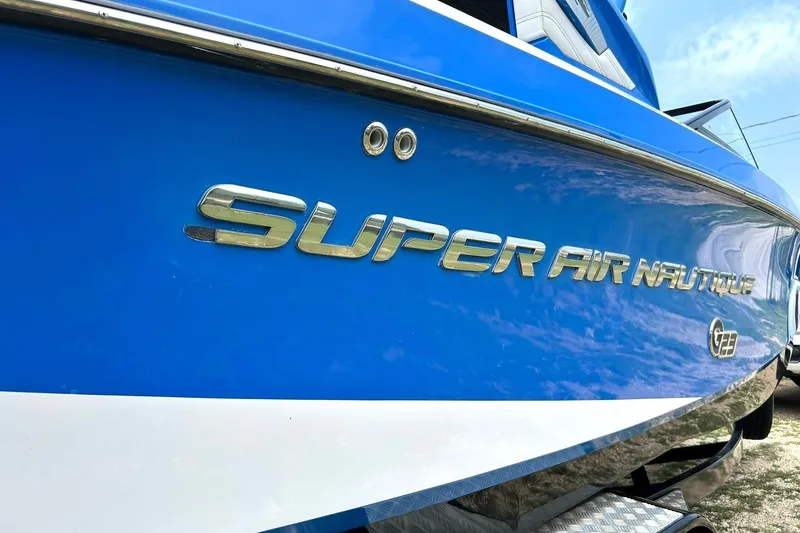 Slide: The Image of 2013 Nautique Super Air Nautique G23 boat, blue exterior with chrome lettering. - 10