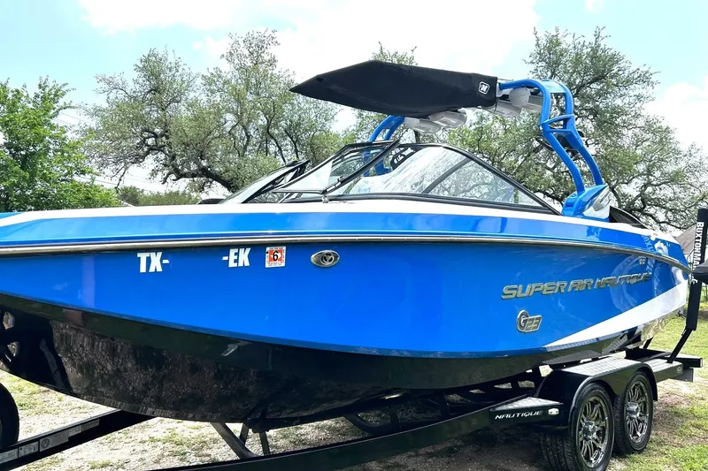Slide: The Image of Blue 2013 Nautique Super Air Nautique G23 boat on trailer, parked outdoors. - 14