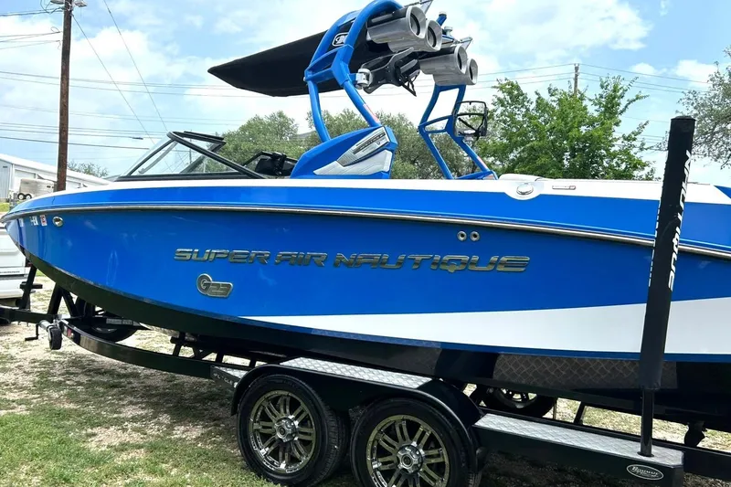 Slide: The Image of 2013 Nautique Super Air Nautique G23 boat in vibrant blue on trailer. - 16