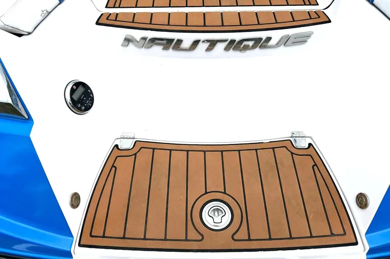 Slide: The Image of 2013 Nautique Super Air Nautique G23 boat deck with logo and teak-style flooring. - 24