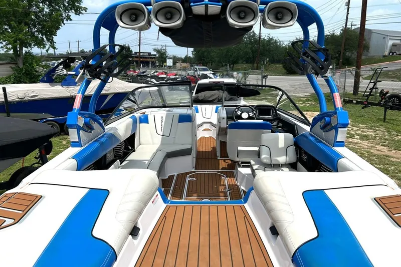 Slide: The Image of 2013 Nautique Super Air Nautique G23 boat interior with blue accents and teak flooring. - 25