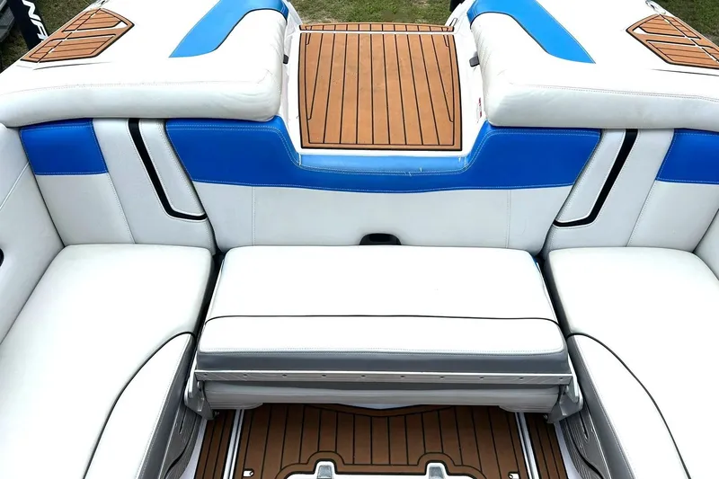 Slide: The Image of 2013 Nautique Super Air Nautique G23 interior with white and blue seating, teak accents. - 26