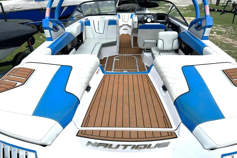 Slide: The Image of 2013 Nautique Super Air Nautique G23 interior with blue and white seating, wooden flooring. - 3
