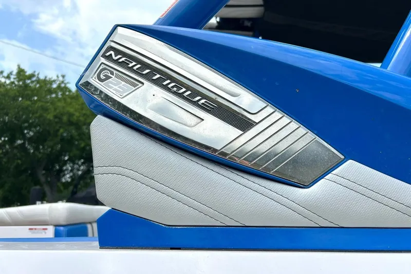 Slide: The Image of Close-up of 2013 Nautique Super Air Nautique G23 emblem on blue and white boat. - 53